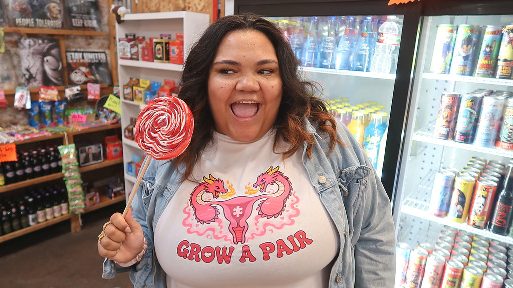 Close-up Poligear Grow a Pair white graphic tee with pink dragon illustration and lollipop